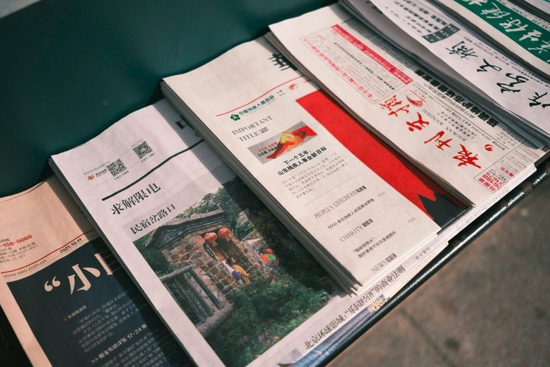 a pile of newspapers sitting on top of a table
